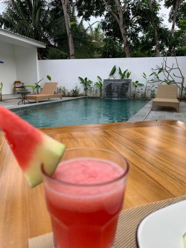 a drink on a table with a slice of watermelon at Kahurangi Hotel in Sekongkang