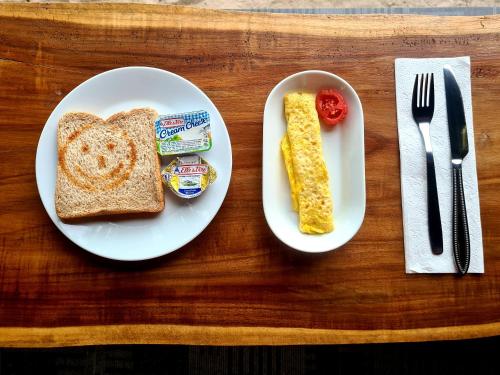 a white plate with toast and butter and a knife and fork at Beach House Penida in Nusa Penida