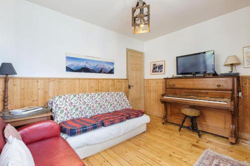- un salon avec un canapé et un piano dans l'établissement Grand Chalet des Moussoux - Happy Rentals, à Chamonix-Mont-Blanc