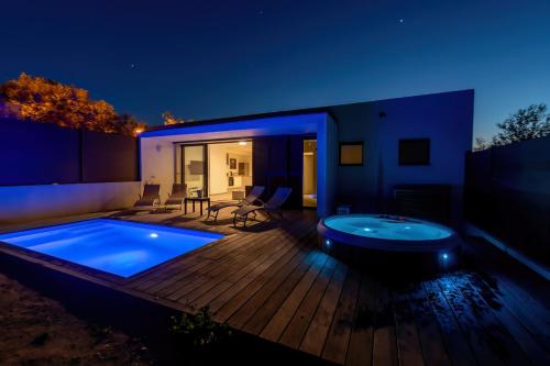 une arrière-cour avec un bain à remous sur une terrasse en bois dans l'établissement Résidence Manon, à Monticello