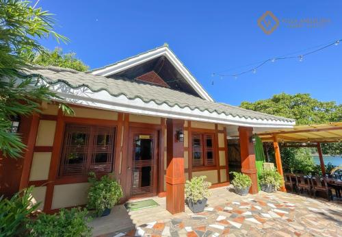 a house with a patio in front of it at Villa Angelina Luxury Suites in Dapitan