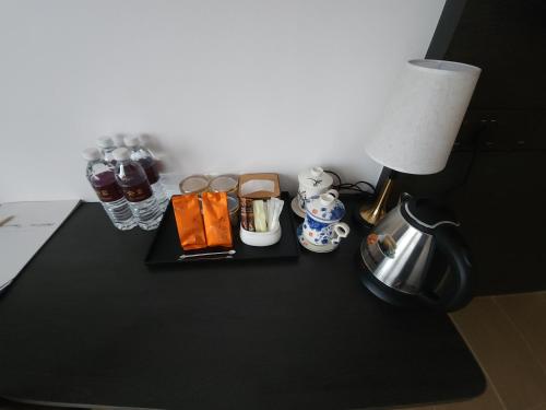 Yu Hotel Chinatown في كوالالمبور: طاولة سوداء مع مصباح وغلاية شاي