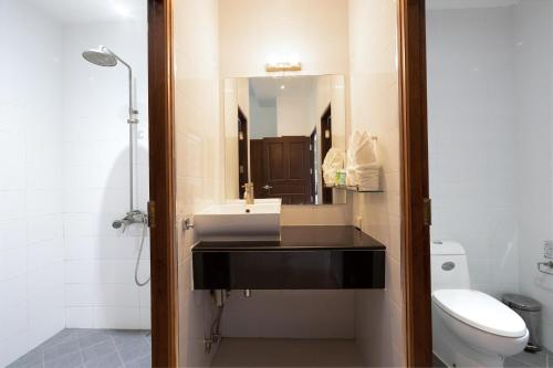 une salle de bain avec un lavabo, des toilettes et un miroir dans l'établissement 1Br Poolside Apartment, Long Beach, Lanta Sport Resort 105, à Ko Lanta