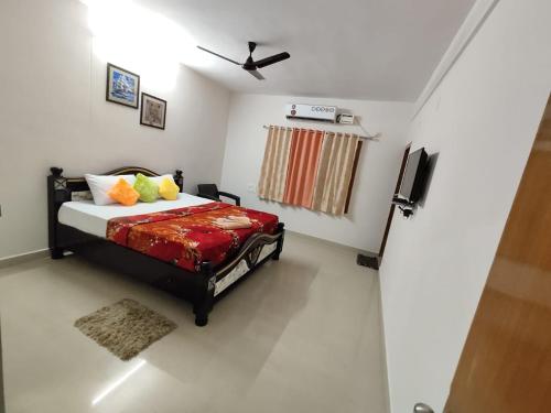 Schlafzimmer mit einem Bett und einem Deckenventilator in der Unterkunft PARADISE HOME STAY in Visakhapatnam
