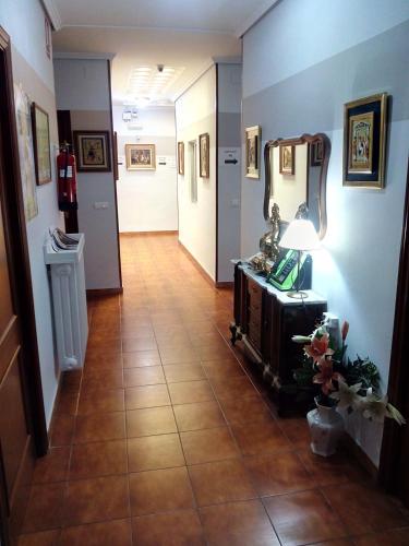 a hallway with blue walls and a tile floor with a mirror at Hotel Europa in Tomelloso