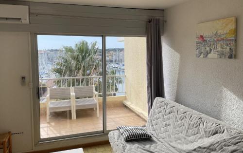 - un salon avec un canapé et une vue sur le balcon dans l'établissement Vue ensoleillée sur le port de Gruissan, à Gruissan