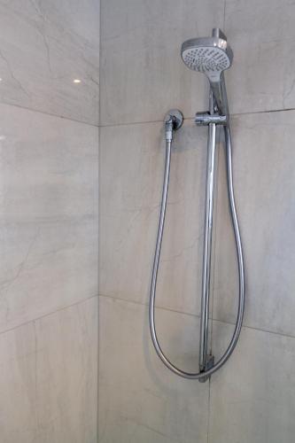 a shower with a shower head in a bathroom at 1 Bedroom Central City Escape in Christchurch