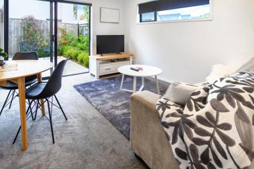 a living room with a couch and a table at 1 Bedroom Central City Escape in Christchurch