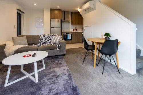 a living room with a couch and a table at 1 Bedroom Central City Escape in Christchurch