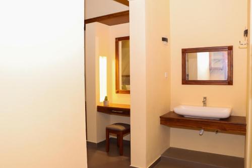 Paddyway Resort في آروغام باي: حمام مع حوض ومرآة