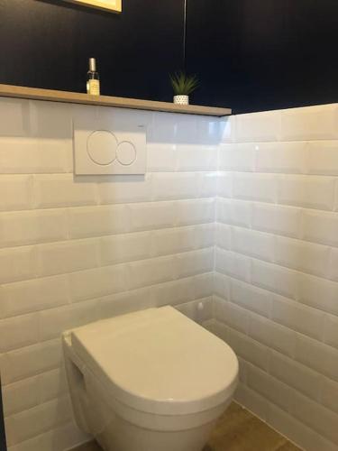 une salle de bain avec des toilettes blanches dans une chambre dans l'établissement La Maison Familiale Ladou, à Barneville-Carteret