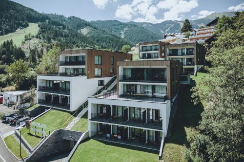 uma vista aérea de um edifício com montanhas ao fundo em Nikolaus by AvenidA Panoramic Wellness Suites em Zell am See