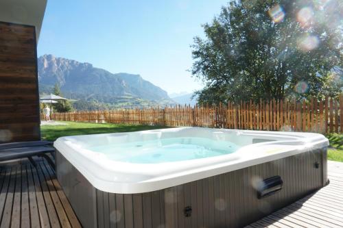 a jacuzzi tub on a deck in a yard at Alpuris - Your Boutique Suite - Hotel B&B in Cavalese