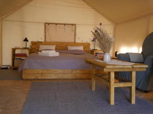 una camera con un grande letto e un tavolo con un tavolino sidro di Mežurgu teltis a Dikļi