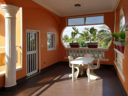 een oranje kamer met een tafel en een raam bij Agbata Guest House 