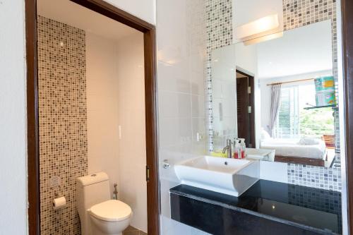 Un baño con lavabo, inodoro y espejo. en 2Br Seaview Apartment, Long Beach, Lanta Sport Resort 302, en Ko Lanta