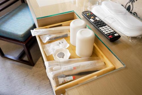 a drawer with a remote control next to a table at 銀座飯店Ginza Hotel in Taipei