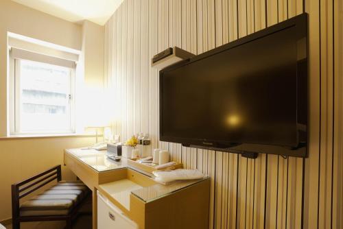 a room with a large television on a wall at 銀座飯店Ginza Hotel in Taipei