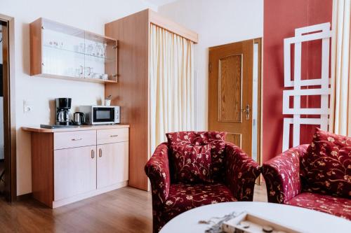 a living room with two chairs and a table at Ferienwohnung am Kurpark in Bad Lauterberg