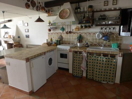 een keuken met een wasmachine en een wastafel bij Casa con vista lago, Civitella Alfedena in Civitella Alfedena