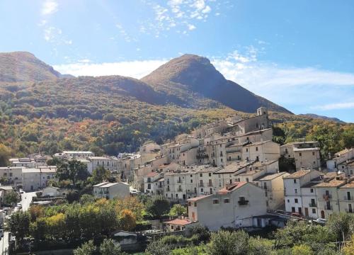 a town on a hill with mountains in the background at Casa con vista lago, Civitella Alfedena in Civitella Alfedena
