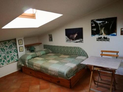 a bedroom with a bed and a table in it at Casa con vista lago, Civitella Alfedena in Civitella Alfedena