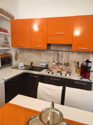 a kitchen with orange cabinets and a sink at Maison Platone Centre in Alessandria