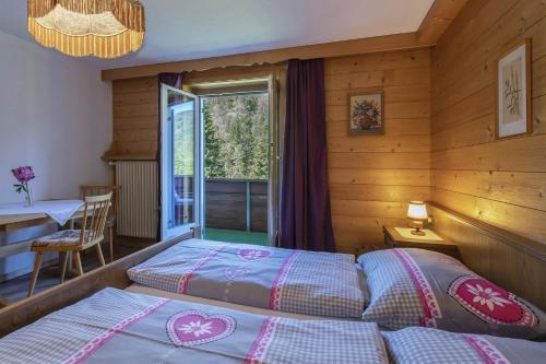 a bedroom with two beds and a table and a window at Ferienwohnung Michael Novablick in Gaschurn