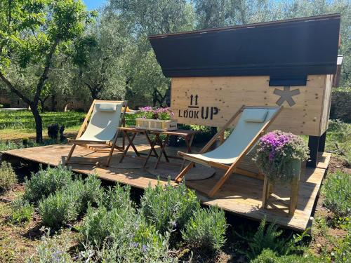due sedie e un tavolo su una terrazza di legno con una casa di #StarsBoxtragliulivi a Molfetta