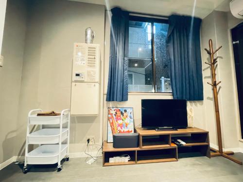 a room with a desk with a television and a window at 东京中心全新装修宽敞明亮的公寓 3分钟步行路程到门前仲町站 两条地铁线直达东京上野新宿201 in Tokyo