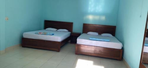 two beds sitting next to each other in a room at Lang Chai Guesthouse in Mui Ne