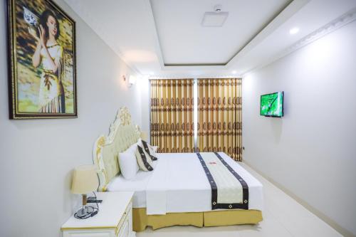 a bedroom with a king sized bed and a table at Khách Sạn Phượng Hoàng 3 in Thanh Hóa