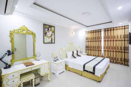 ein Schlafzimmer mit einem Bett, einem Waschtisch und einem Spiegel in der Unterkunft Khách Sạn Phượng Hoàng 3 in Thanh Hóa