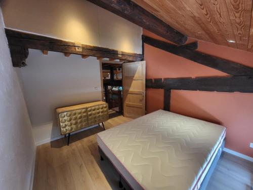 um pequeno quarto com uma cama num sótão em Gite Familiale La Classe em Modave
