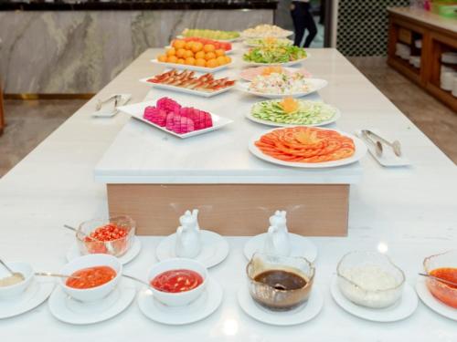 een buffet met eten op een tafel met borden bij Tahiti Resort in Phu Quoc