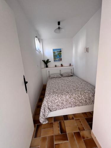 une chambre avec un lit dans une pièce blanche dans l'établissement Sympathique studio en Rez de jardin dans résidence, à Hyères