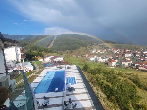 a rainbow over a house with a swimming pool at Вилно селище PARADISE VIEW in Sarnitsa