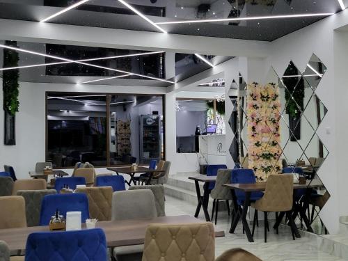 a restaurant with tables and chairs and a tree at Вилно селище PARADISE VIEW in Sarnitsa