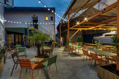 un patio con tavoli, sedie e barca di Le Lieu Dit a Nantes