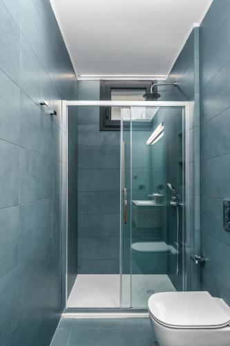 a bathroom with a glass shower and a toilet at Kalma Luxury Villas in Kalamata
