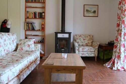 a living room with a couch and a table and a stove at Kołatek Mazury Apartament z widokiem in Olsztynek