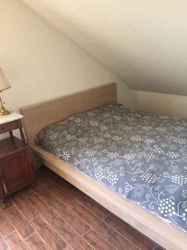 a small bedroom with a bed and a night stand at Kołatek Mazury Apartament z widokiem in Olsztynek