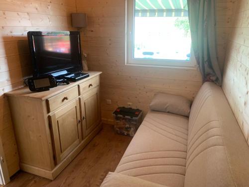 a living room with a couch and a flat screen tv at Ferienhaus Spielburg in Altötting