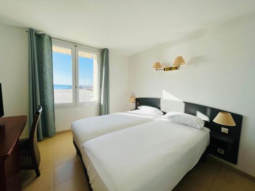 パラヴァ・レ・フロにあるLes Alizesのベッドルーム1室(ベッド2台付)が備わり、海の景色を望めます。