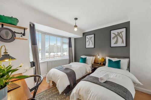 1 dormitorio con 2 camas y ventana en Stylish Maisonette near the heath with Free parking & Wi-Fi en Kent