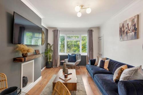 a living room with a blue couch and a table at Stylish Maisonette near the heath with Free parking & Wi-Fi in Kent