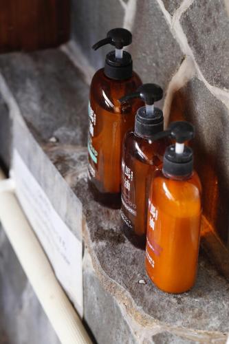 four bottles of honey sitting on a stone wall at 湯布院我楽珍民泊Yufuin Garakuchin in Yufuin
