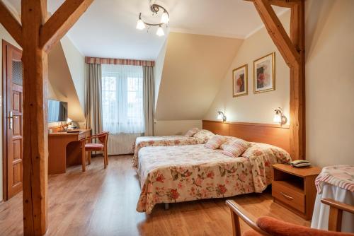 a hotel room with two beds and a desk at Lech Resort & Spa in Łeba