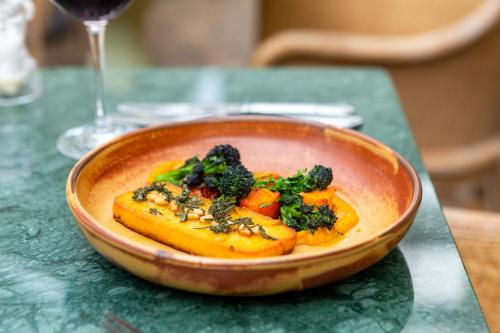 a bowl of food with broccoli and carrots on a table at The Barnsdale, Rutland in Oakham