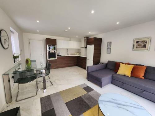 sala de estar con sofá y mesa de cristal en Panorama House, Luxury 2-Bedroom Apartment 2, en Kidlington